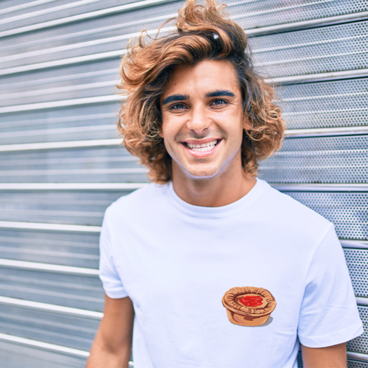 Man wearing a white t-shirt with printed meat pie design  standing in front of a metallic shutter.